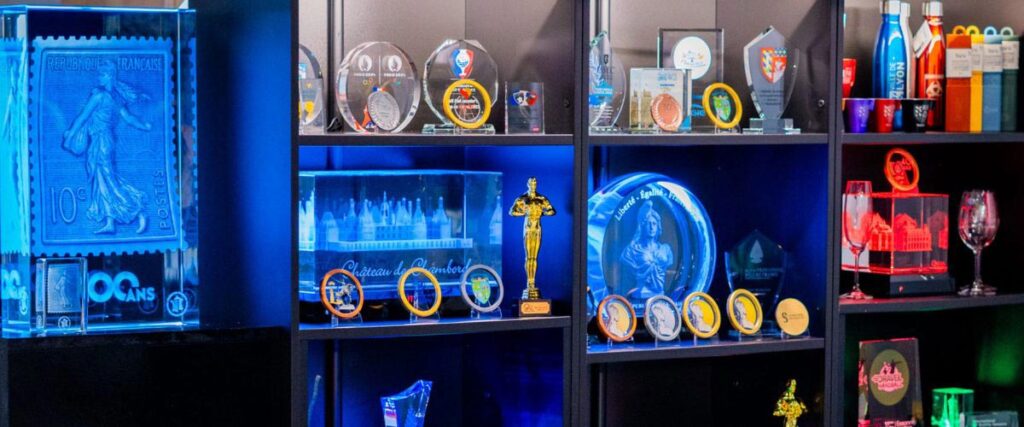 Présentation en vitrine de trophées, médailles et objets personnalisés pour collectivités, mairies et événements officiels.