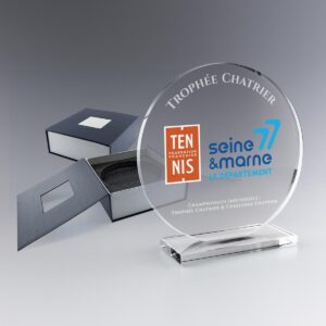 Trophée rond en verre sur socle, personnalisé avec les logos du tennis français et de la Seine-et-Marne, accompagné de coffrets.